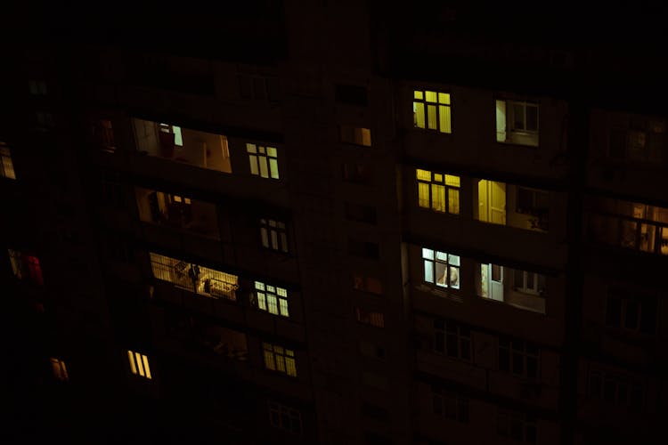 Night Photo Of An Apartment Building With Illuminated Windows