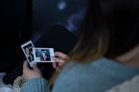 Woman Holding Two Photos