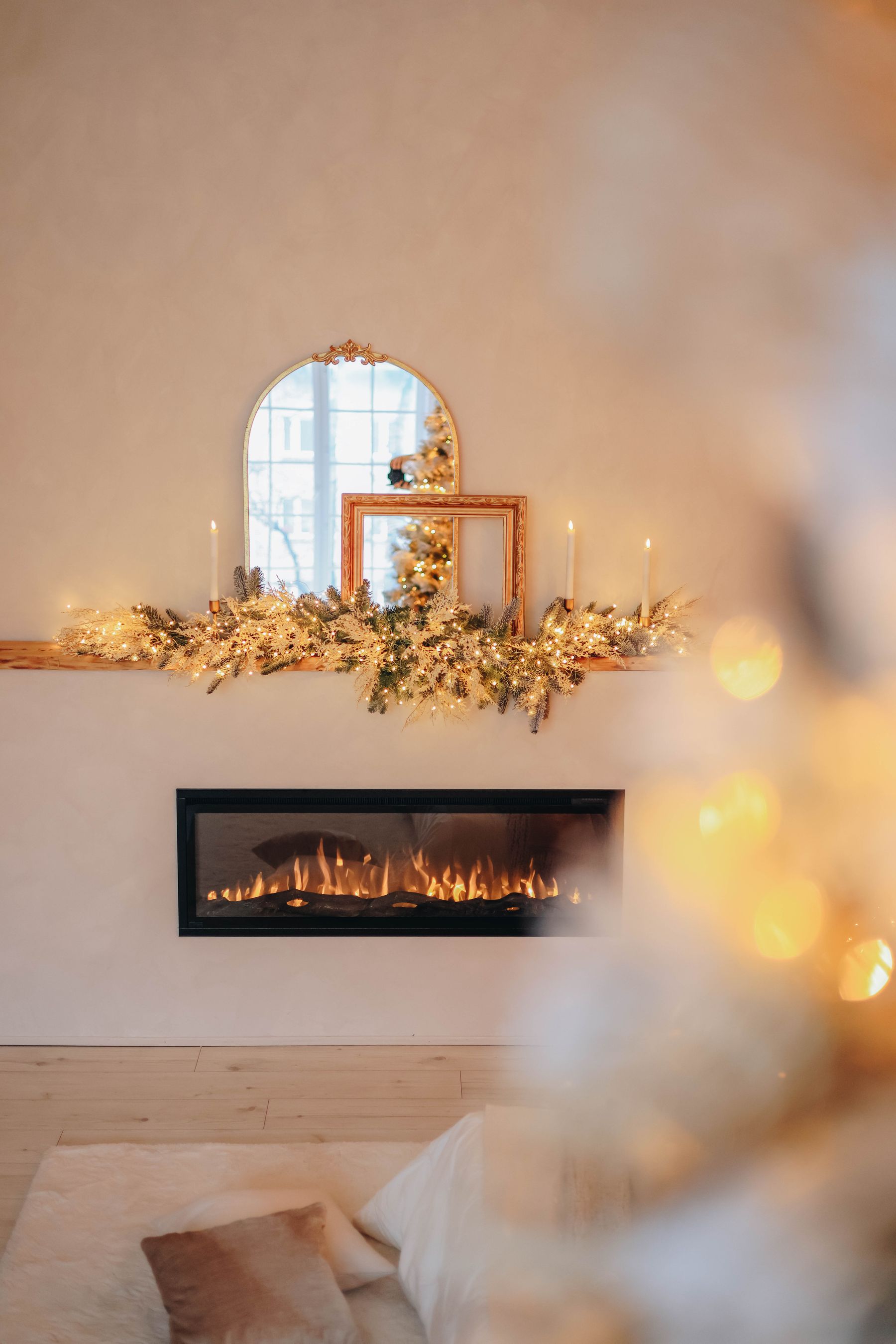 Modern fireplace mantel with Christmas greenery and a mirror