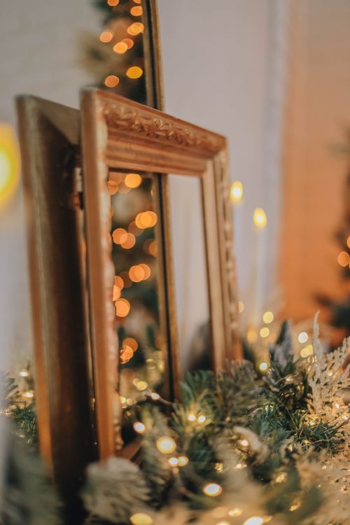 Free A decorative mirror surrounded by festive lights and evergreen leaves, creating a warm holiday ambiance. Stock Photo