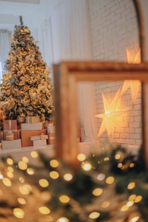Free Cozy indoor Christmas scene with a decorated tree and glowing star lights. Stock Photo