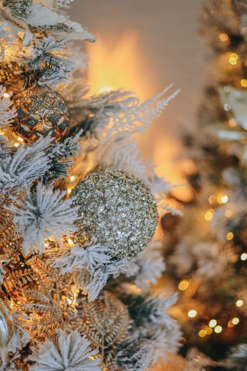 Free Close-up of a Christmas tree with gold and white ornaments and lights. Stock Photo