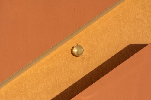 Close-up of an Orange Facade of a Building with a Small Lamp 