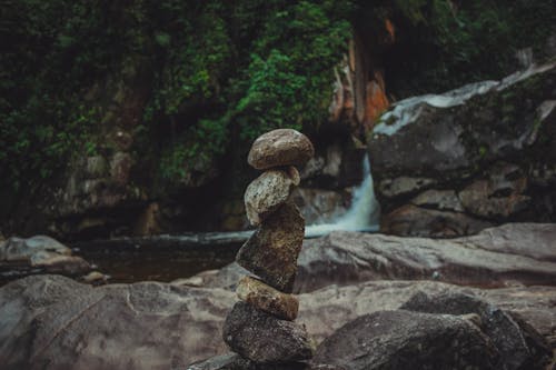 Close-up of a Stack of Stones on the Background of a Waterfall 