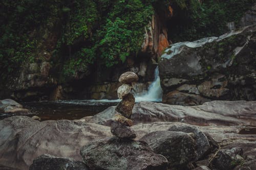 Close-up of a Stack of Stones on the Background of a Waterfall