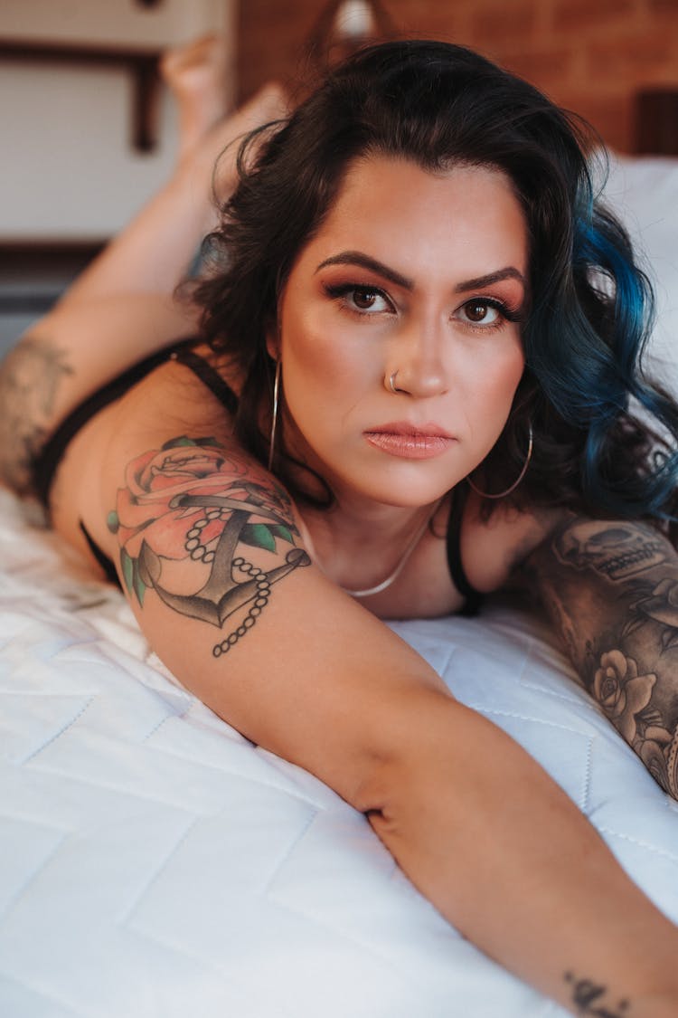 Tattooed Model Lying On A Bed