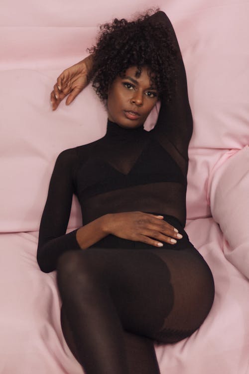 Free Young Woman in a Black Outfit Posing on a Couch  Stock Photo