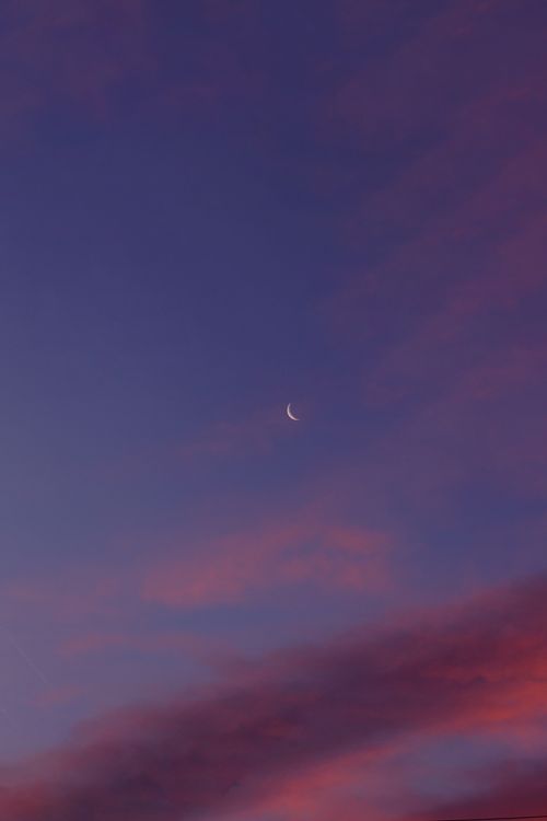 Free A serene crescent moon set against a vivid purple and pink twilight sky, perfect for calm-themed projects. Stock Photo