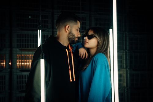 Free A fashionable couple poses amid neon lights in an urban setting, Tehran. Stock Photo