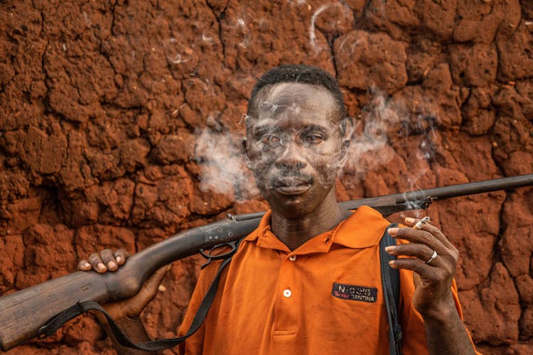 Man Holding A Gun And Smoking A Cigarette 