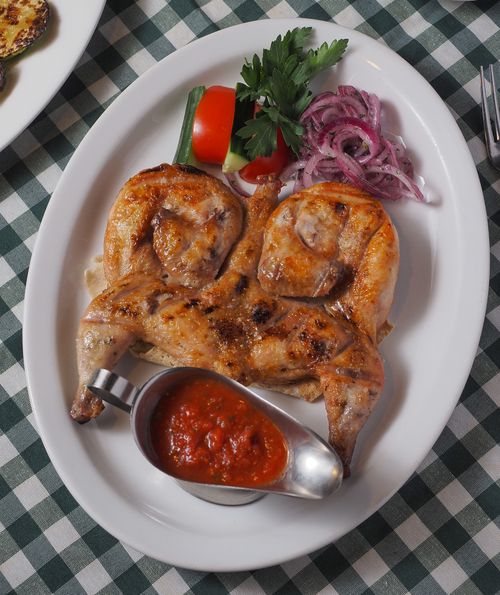 Free Appetizing grilled chicken with dipping sauce on a white plate, accompanied by vegetables. Stock Photo