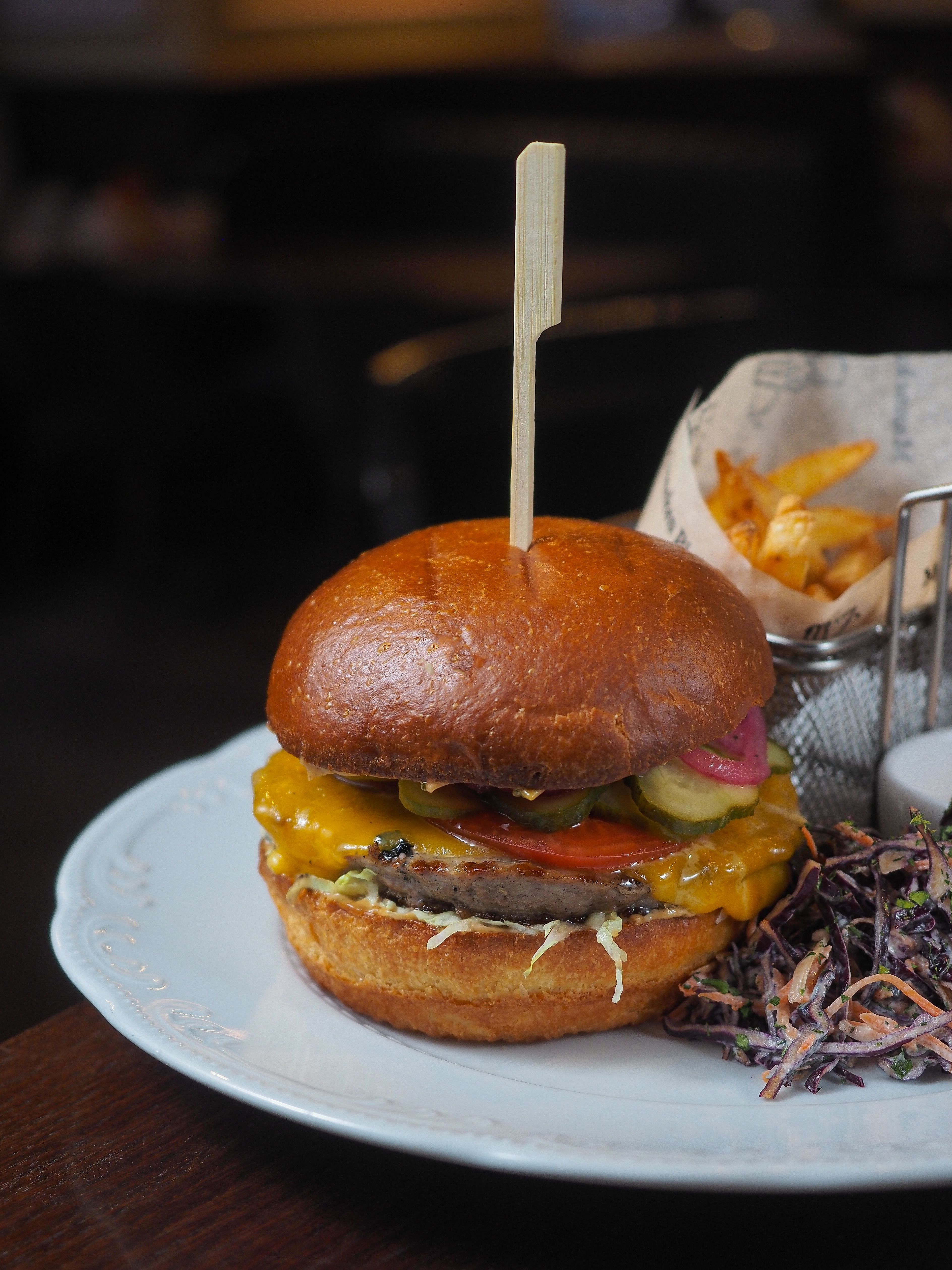 Tasty cheeseburger served with crispy fries and coleslaw on the side.