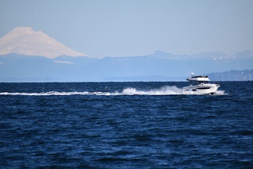 A Motorboat on the Sea with the View of a Large Mountain in the Background 