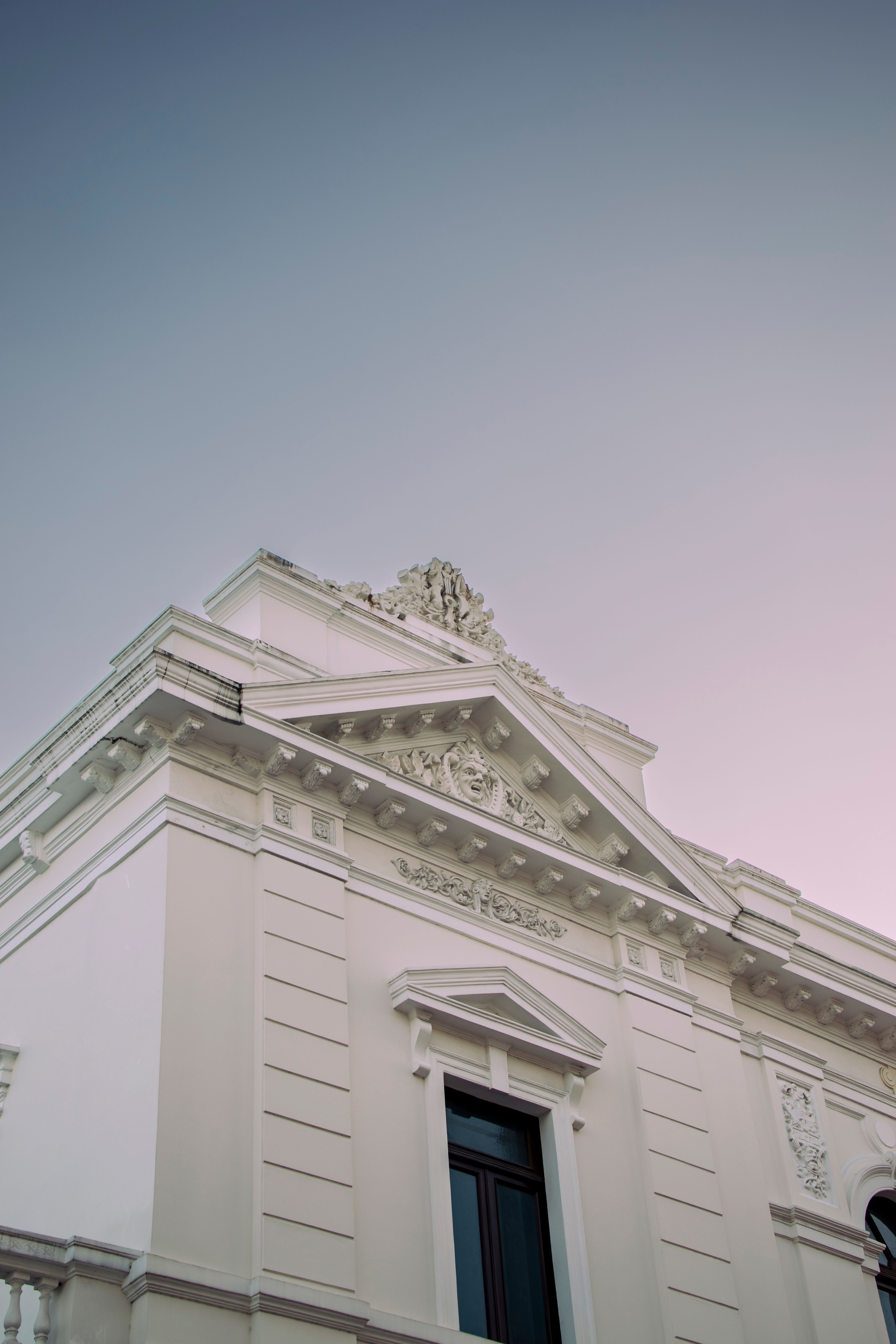 Low Angle Shot of a White Building with Caved Details under Blue Sky ...