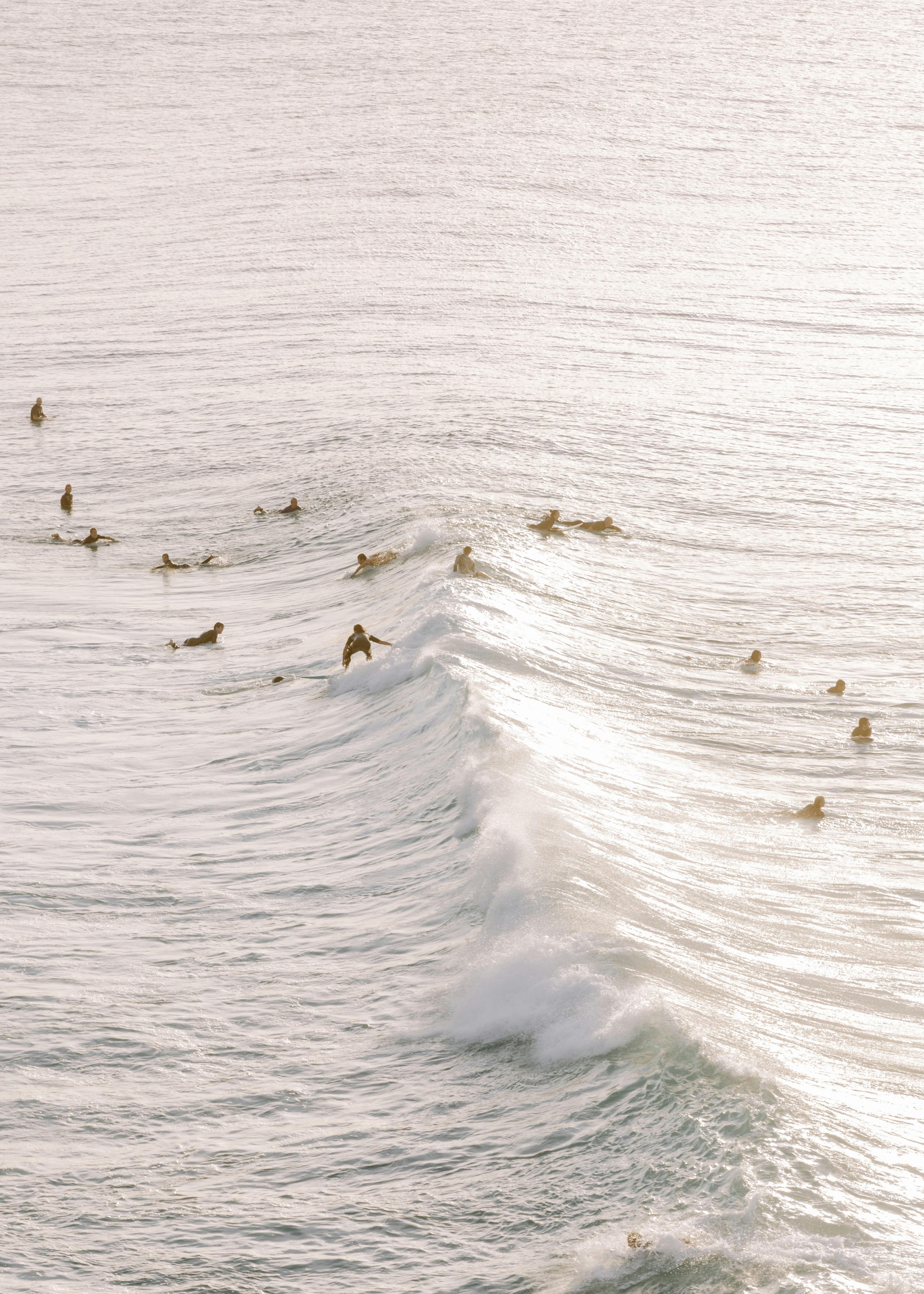 A group of surfers riding waves at Gold Coast, Australia during a beautiful sunny day.