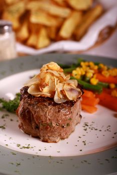 Delicious beef steak served with vegetables and garnished with herbs.