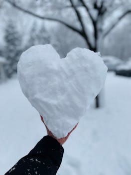Close-up of a heart-shaped snow, creating a romantic winter scene.