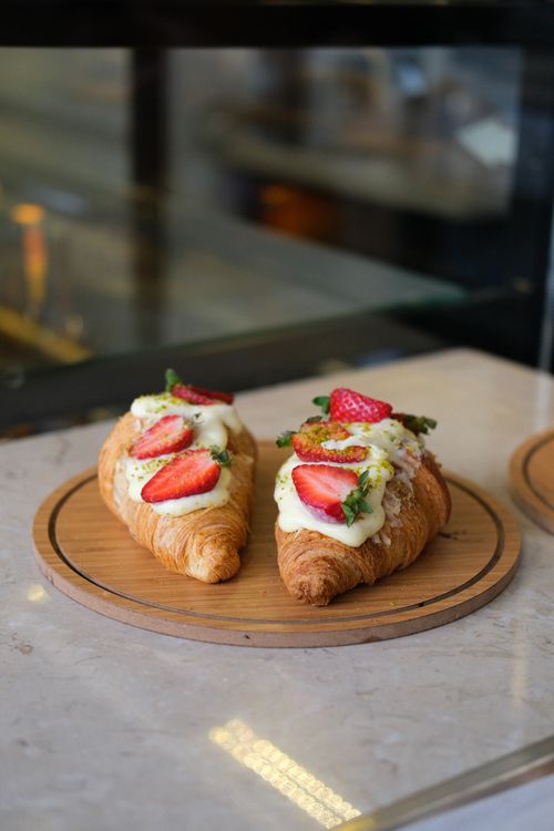 Free Tasty croissants topped with fresh strawberries and cream on a cafe table in İstanbul. Stock Photo