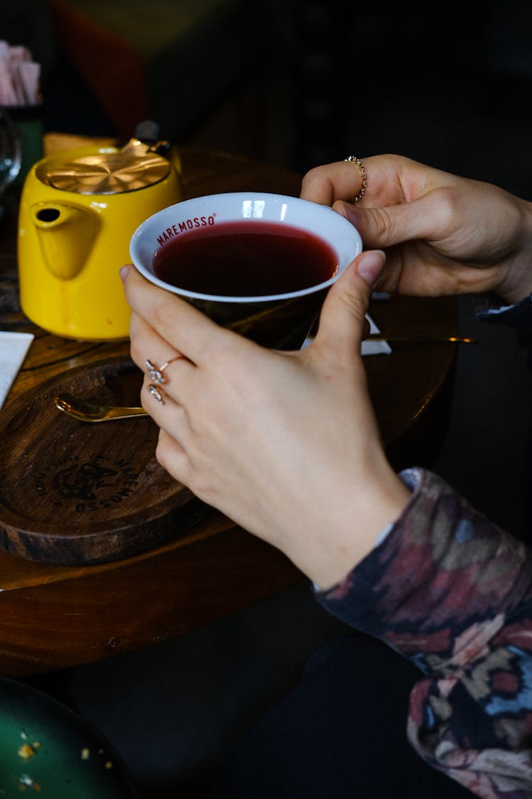 A Person's Hands Holding A Cup Of Tea