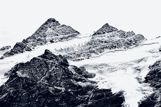 Stunning black and white photograph capturing snow-covered mountain peaks in a winter landscape.