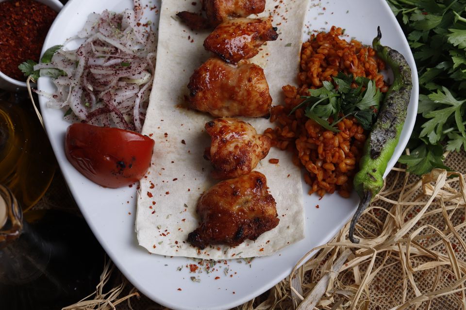 Grilled chicken thighs on flatbread with onions and herbs — photo by Mustafa Erdağ on Pexels