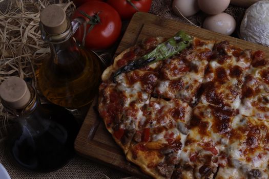Close-up of cheesy pizza with fresh ingredients on a wooden board.