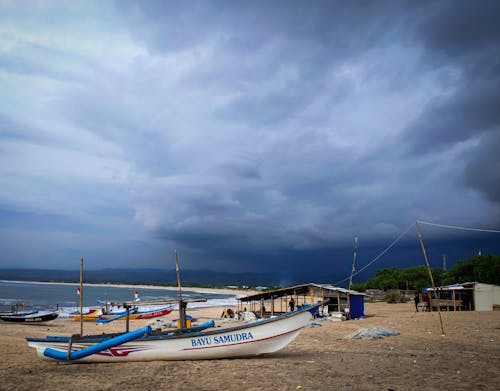 View of Boats on a Beach under a Dark Sky 
