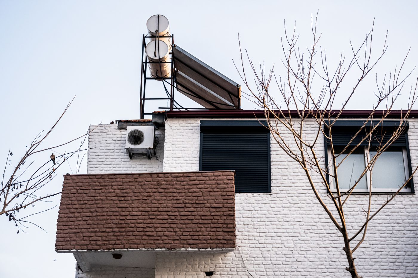 Minimalist home exterior with outdoor air conditioning unit in winter