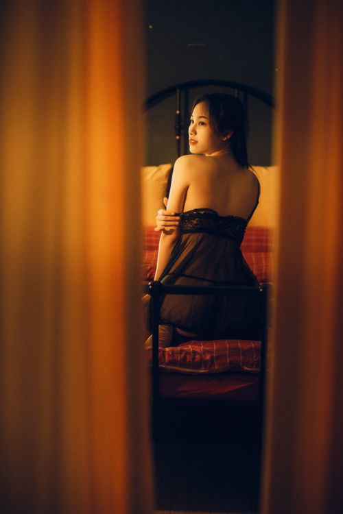 Free Back view of an Asian woman posing gracefully in lingerie, creating a soft and intimate mood. Stock Photo