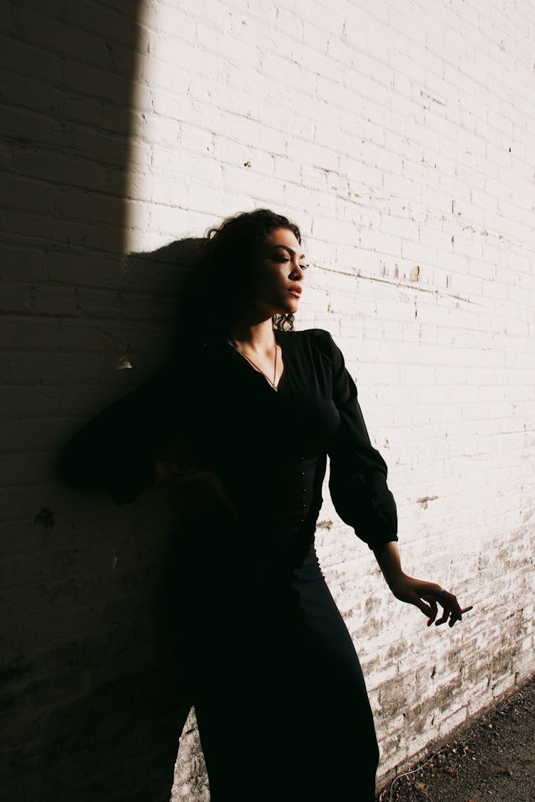 Woman Posing In Shadow Near Sunlit Wall