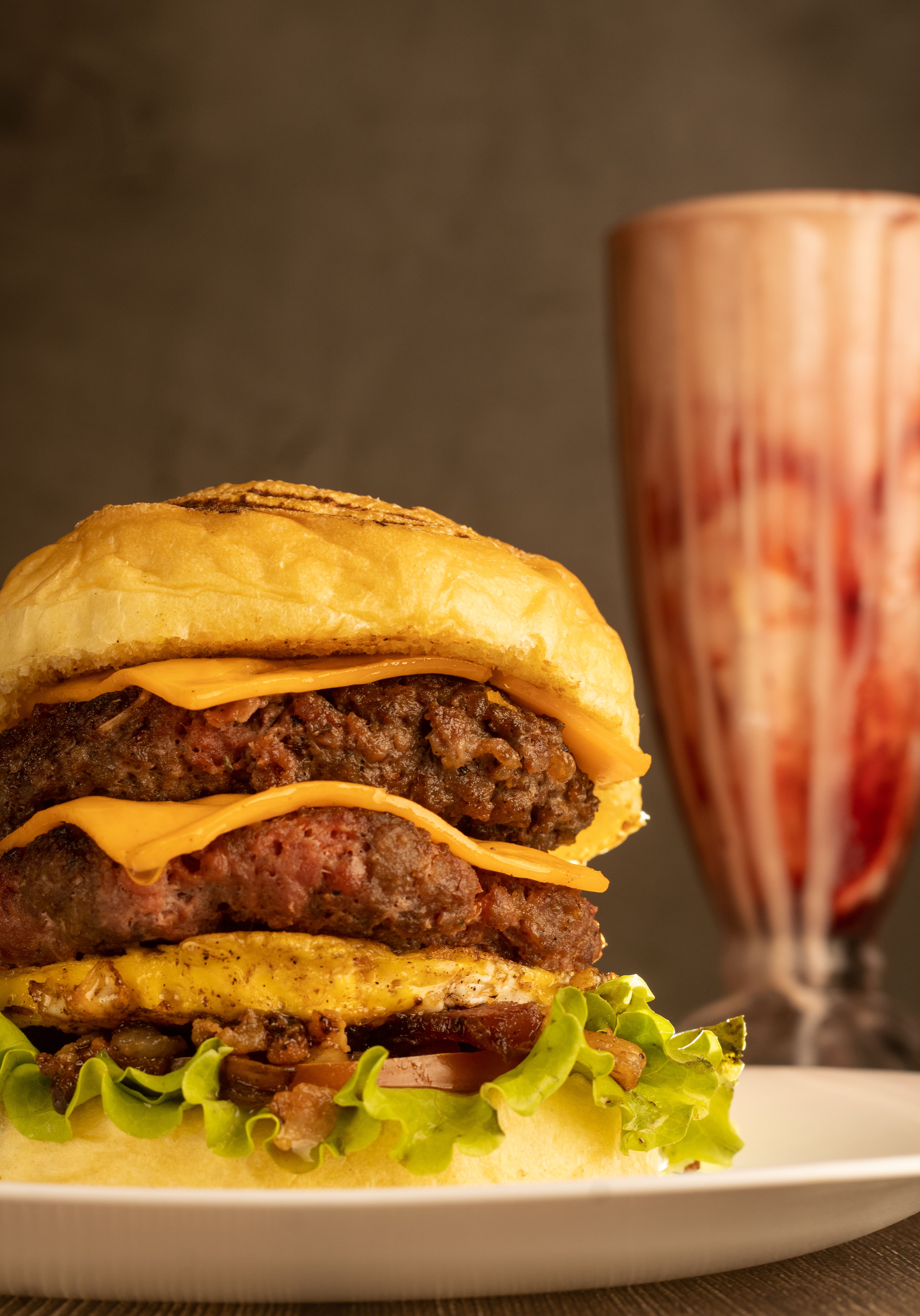 Gourmet cheeseburger with layers of cheese and beef, paired with a milkshake in Belem, Brazil.