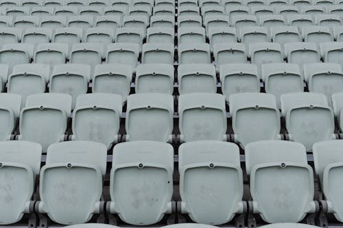 Black and White Photo of Plastic Chairs in the Grandstands 