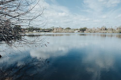 Free Calm quiet lake scene reflecting sky and trees, perfect for tranquility. Stock Photo