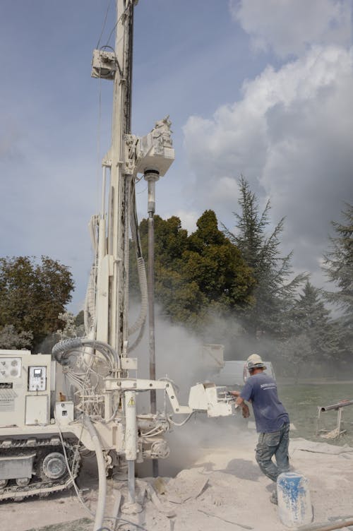 Photo of a Man Working with a Drilling Rig