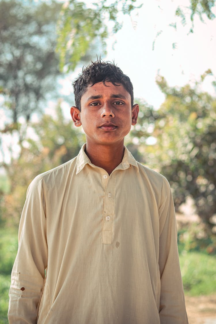 A Boy In A Shirt Standing In A Park 