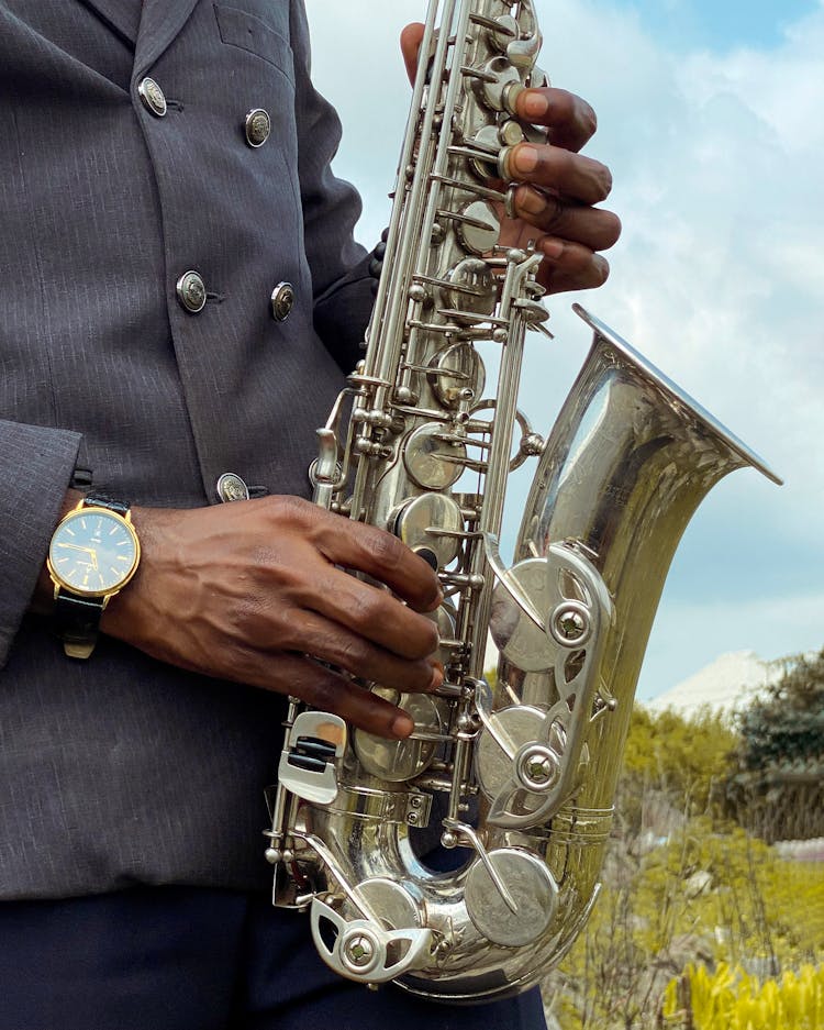 Close-up Of Man Standing Outside And Playing A Saxophone 