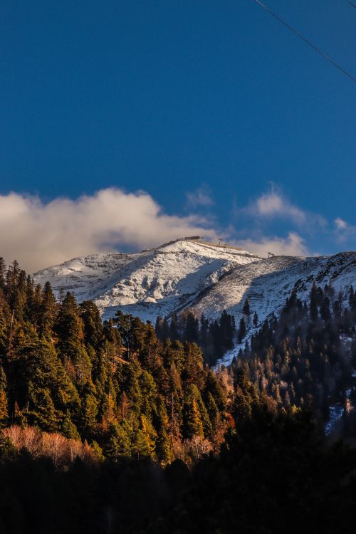 Free Breathtaking view of snow-covered peaks and lush forests under a clear sky in Türkiye. Stock Photo