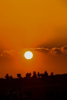 Vibrant sunset with an orange sky over Türkiye's scenic landscape.