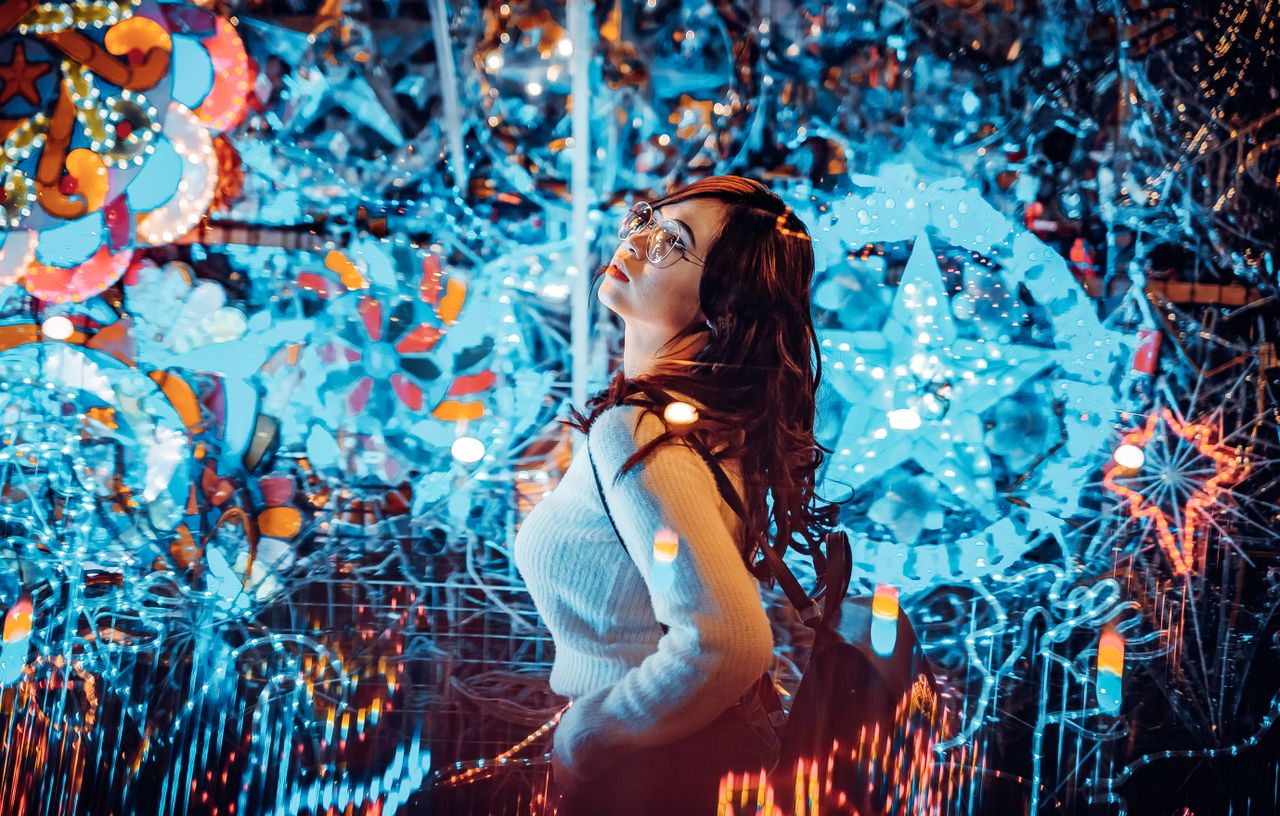 a woman amidst colorful neon lights and festive christmas decorations