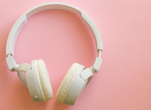 White Headphones on Pink Surface