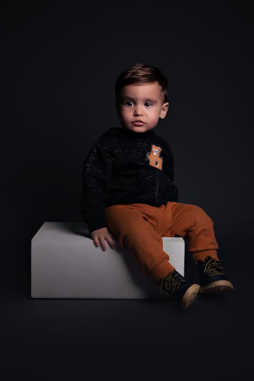 Studio Shot of a Little Boy in Brown Pants and Black Hoodie 