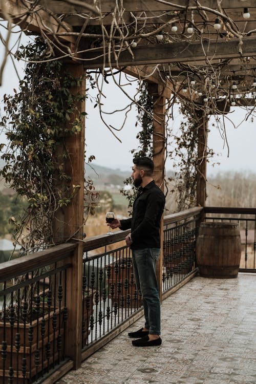 Man Standing on a Terrace with a Glass of Wine