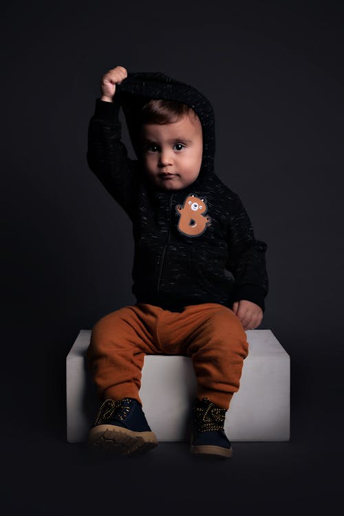 Studio Shot of a Little Boy in Brown Pants and Black Hoodie 