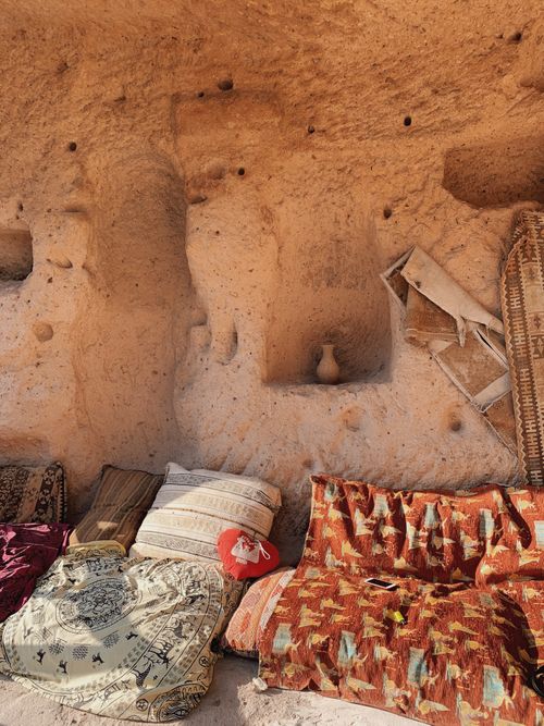 Free Colorful cushions arranged against a carved stone wall in Türkiye, showcasing traditional patterns. Stock Photo