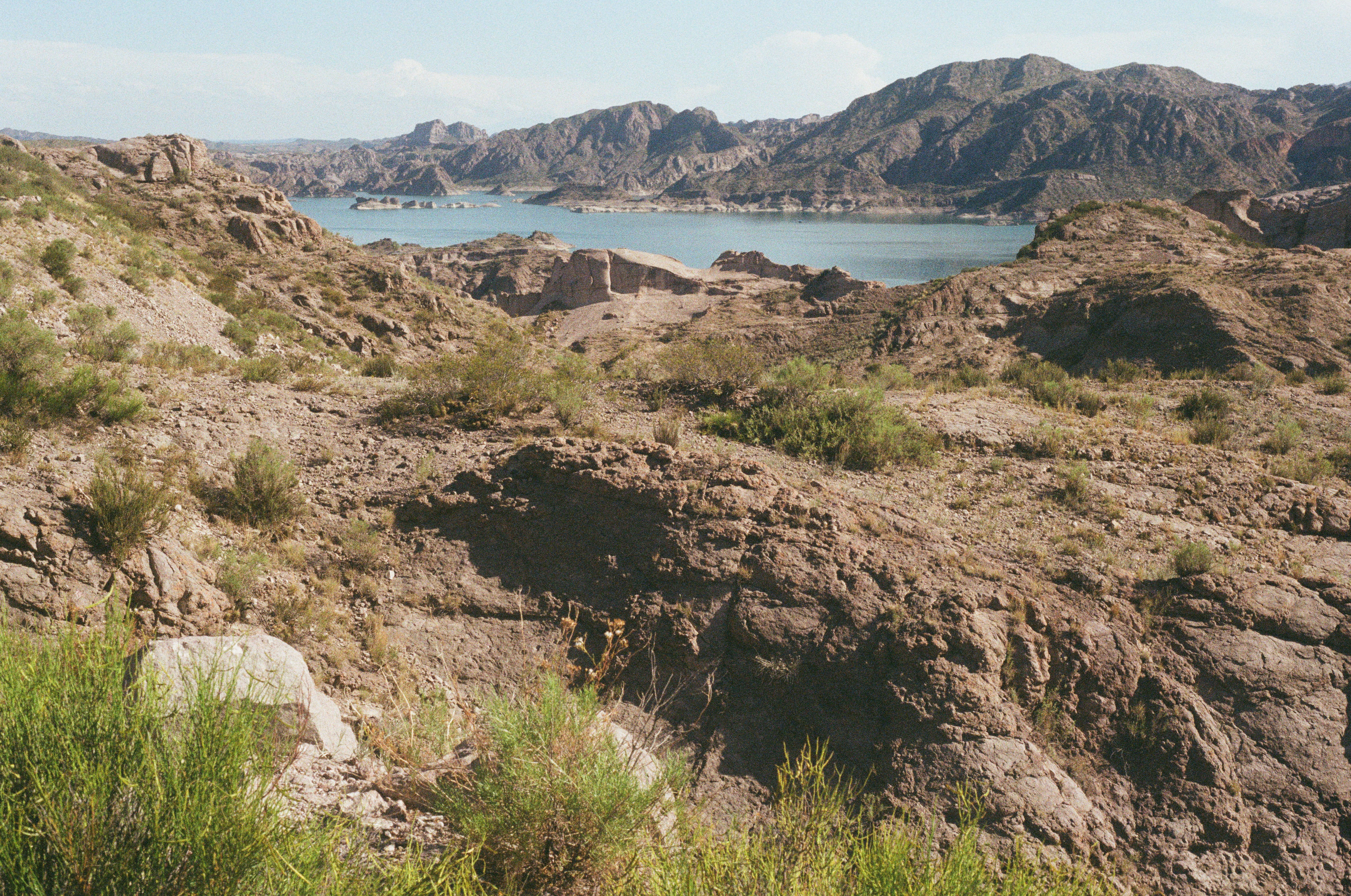 Arid Rocky Desert with a Small Lake and Mountains · Free Stock Photo