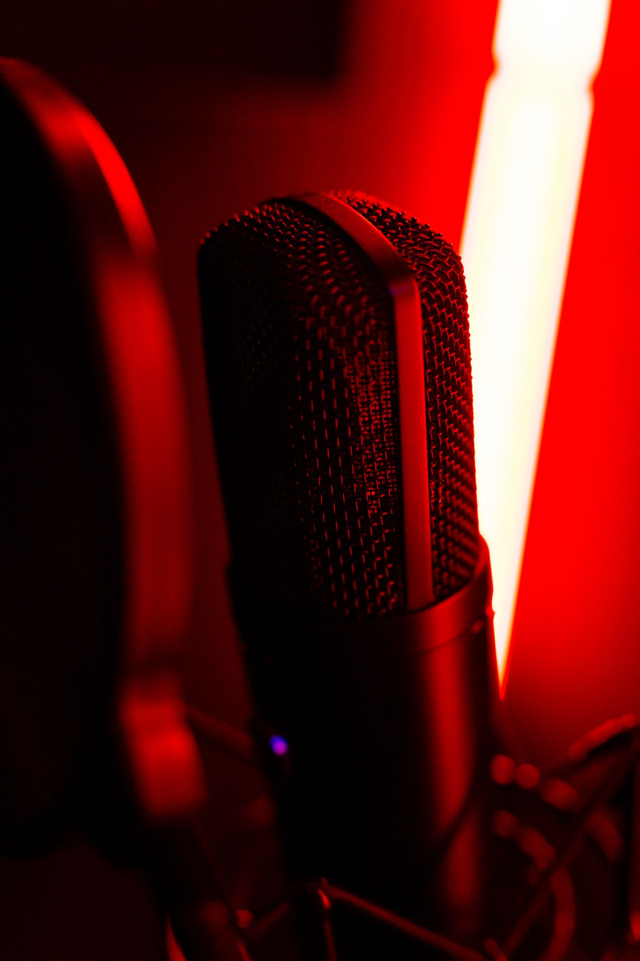 Close-up of a microphone illuminated by red neon lights