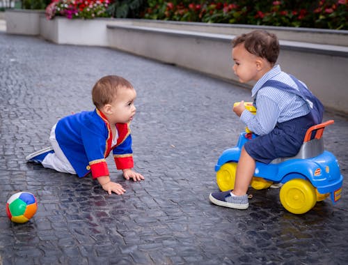 Two Baby Boys Playing Outdoors 