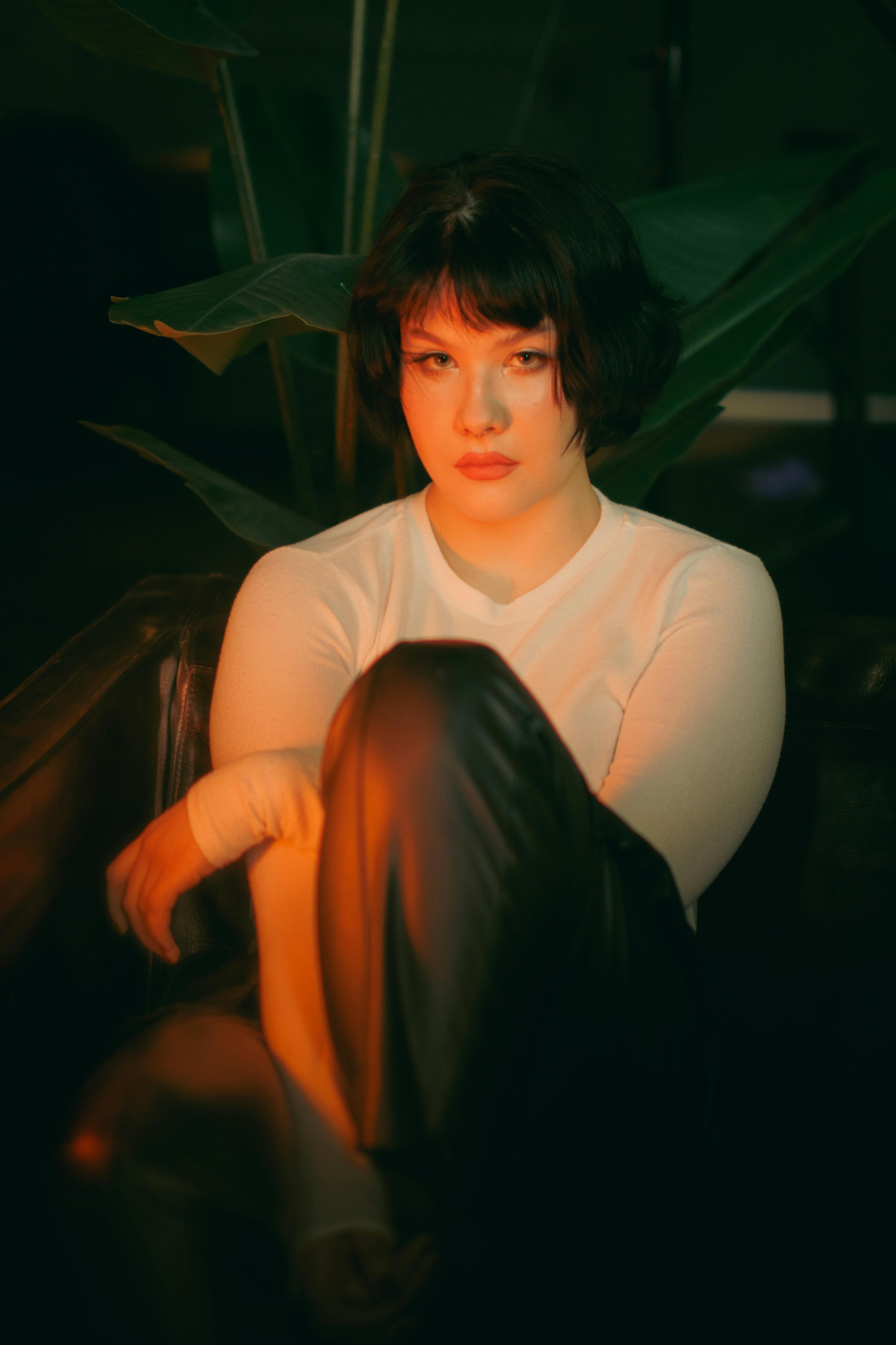 A moody portrait of a woman with short hair in dramatic lighting, creating an intense atmosphere.