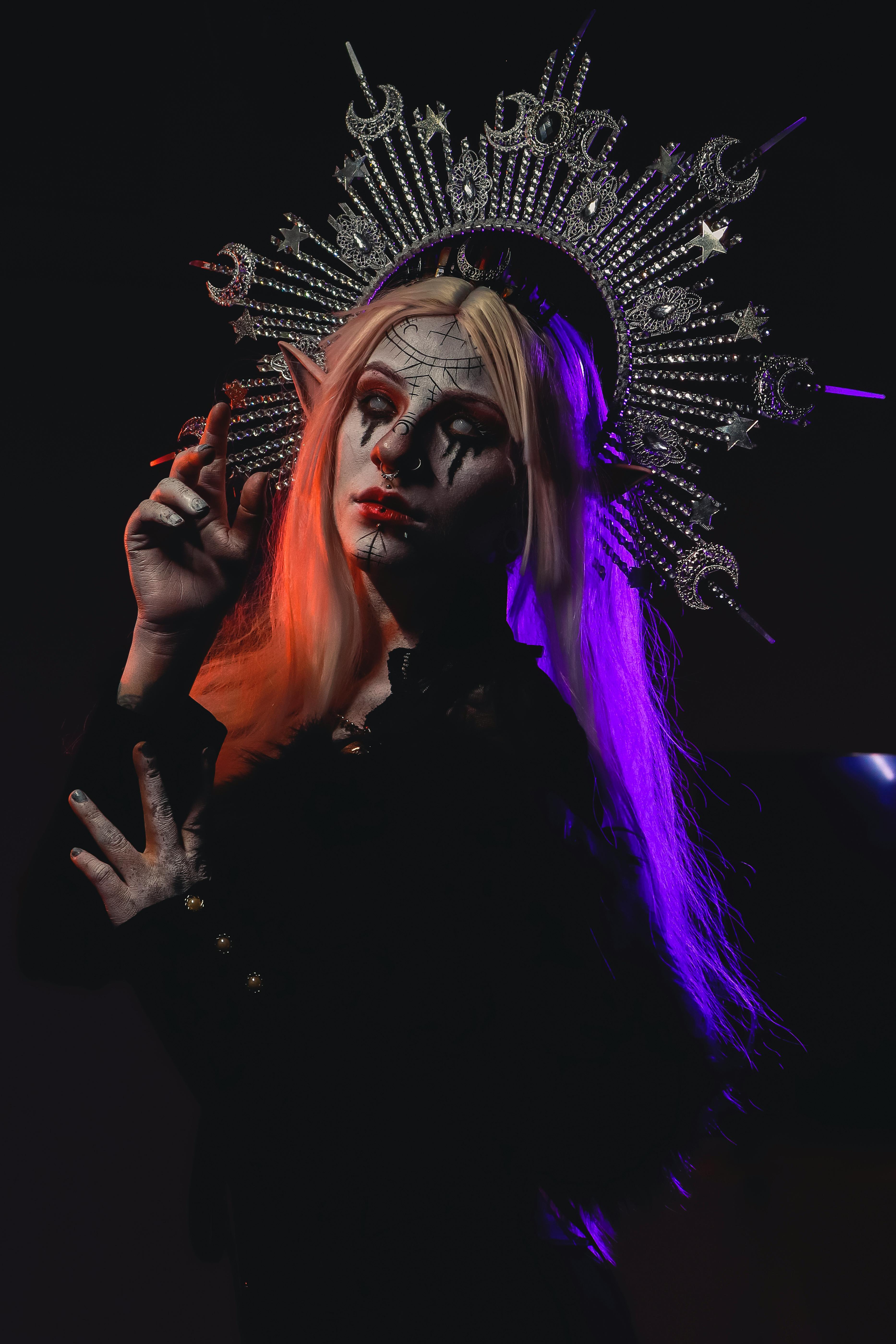 Mysterious woman dressed in dark fantasy attire with an ornate crown, creating a spooky atmosphere.