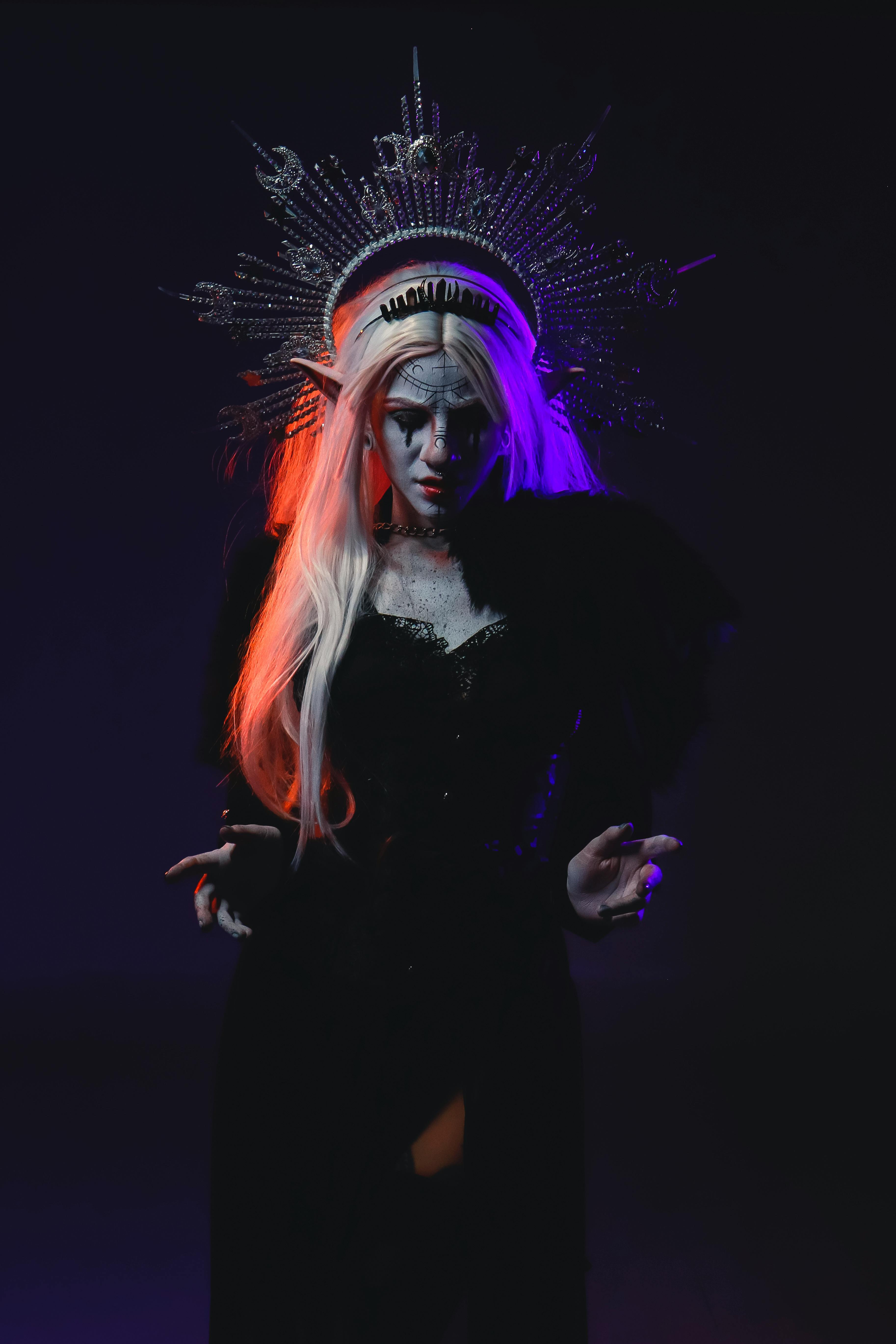 Eerie woman in elaborate costume and headdress with dark, mystical Halloween ambiance.